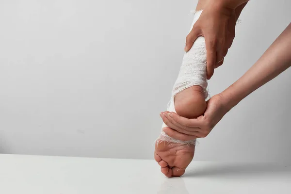 Injured leg bandaged with a bandage pain medicine close-up — Stock Photo, Image