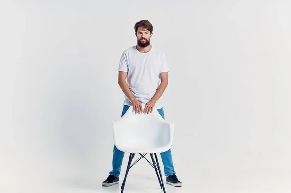 cute man with chair  posing on light background. High quality photo