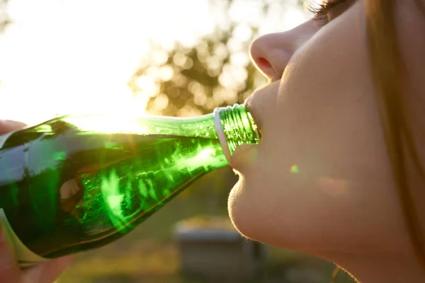 Csinos nő ivóvíz egy zöld üveg közelkép — Stock Fotó