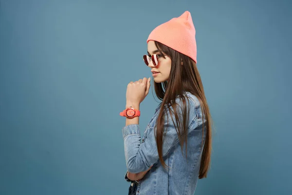 Femme en chapeau rose lunettes de soleil jean veste hipster fond bleu — Photo