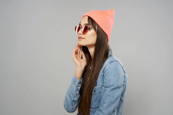 Bonita mujer en denim camisa gafas de sol rosa sombrero posando gris de moda fondo estudio — Foto de Stock