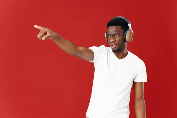 Hombre de aspecto africano en los auriculares fondo rojo Copiar espacio — Foto de Stock