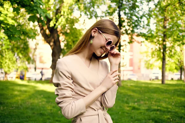 Bonito mulher óculos de sol e um chapéu no parque modelo de grama verde — Fotografia de Stock