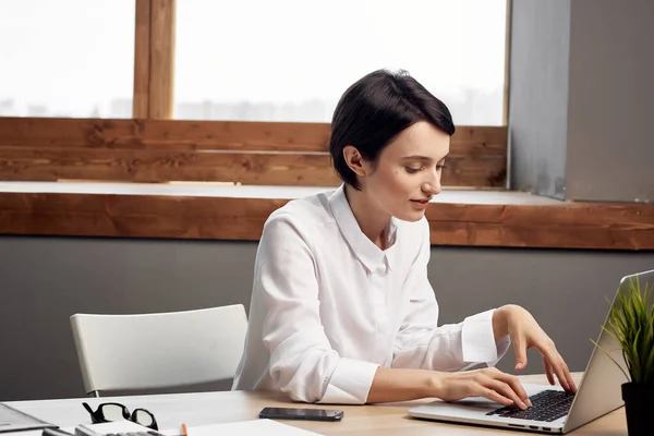 Femme assise à son bureau dans le bureau devant un cadre professionnel de travail d'ordinateur portable — Photo