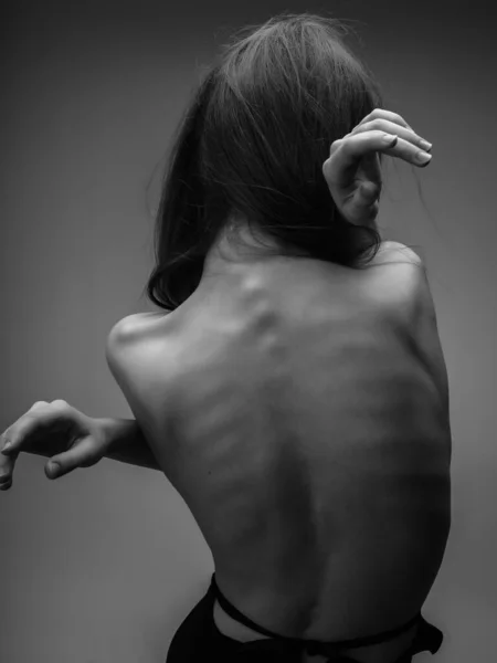 Vacker kvinna poserar naken rygg studio svart och vitt foto — Stockfoto