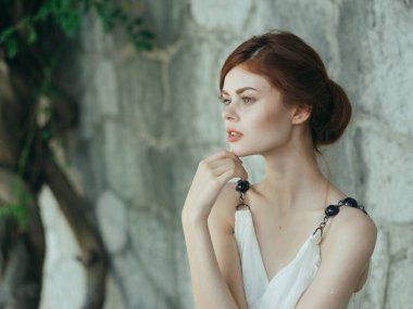 Beyaz elbiseli kadın, ağaç duvarı dekorasyonunun yanında yaşıyor.