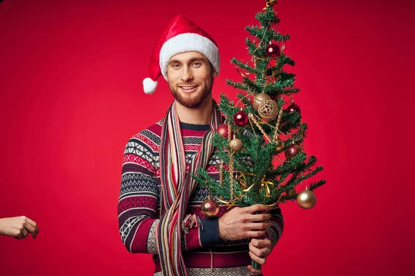 Süslü Noel ağacı olan bir adam Noel tatili, eğlenceli kırmızı arka plan — Stok fotoğraf