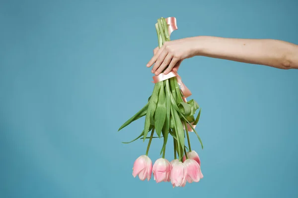 Букет квітів в руках романтика подарунок синій фон — стокове фото