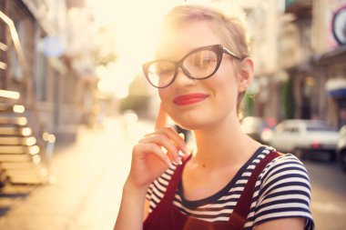 Gözlüklü kadın kozmetik ürünleri ve sokakta yürüyen polis.