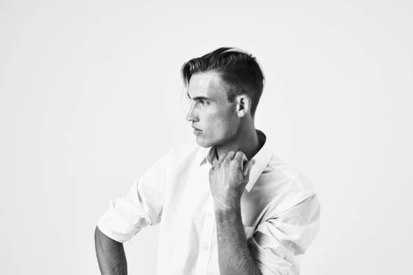 Een man met een modieus kapsel in een wit shirt aantrekkelijk uiterlijk model — Stockfoto