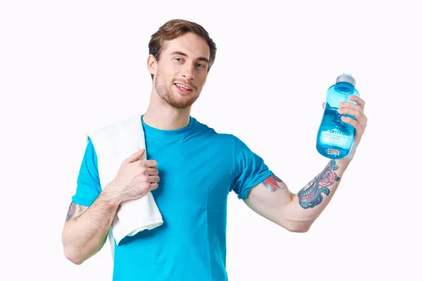 Un uomo in una t-shirt blu manubri nelle mani di un allenamento fitness — Foto Stock