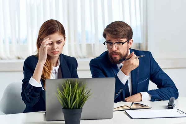 business man and woman teamwork in the office with laptop professionals