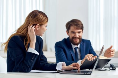 Erkek ve kadın yöneticiler dizüstü bilgisayar profesyonelleri teknolojisi önünde birlikte çalışırlar.