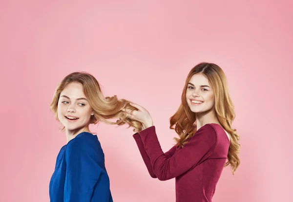 两个穿着华丽服装的快乐女友工作室时尚友谊粉色背景 — 图库照片