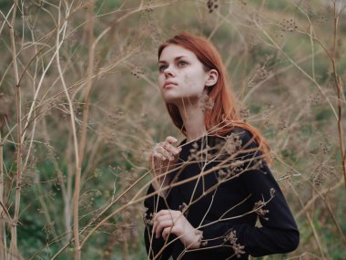 Siyah elbiseli kadın dağ yürüyüşü yapıyor.