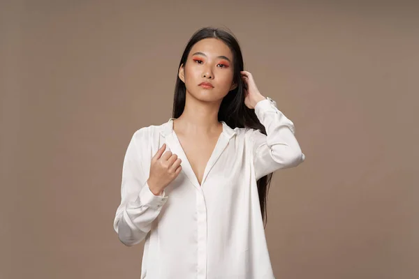 Kvinna asiatisk utseende ljus makeup lyx beige bakgrund — Stockfoto