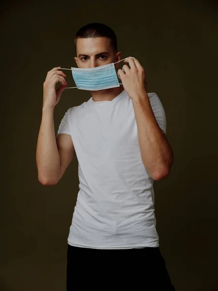Man with a medical mask in his hands the dark background vaccination covid passport — Stock Photo, Image