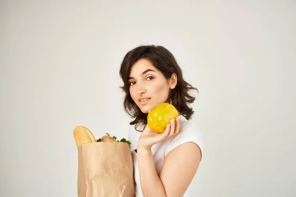 Linda morena en paquete de camiseta blanca con productos alimenticios saludables —  Fotos de Stock