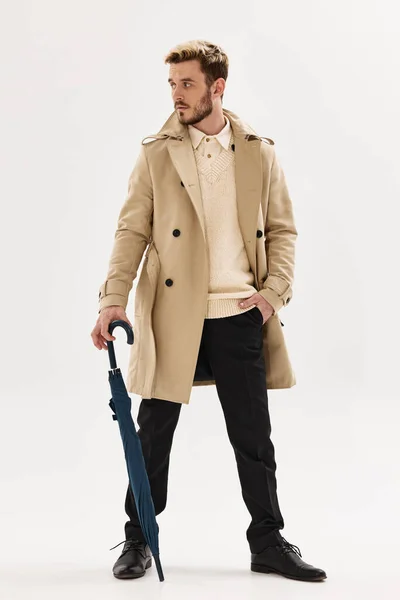 man with umbrella beige coat modern style and rain protection