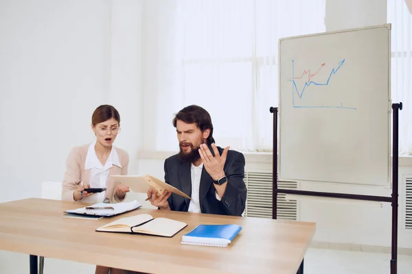 Hombre y mujer de negocios sentados en la mesa de trabajo comunicación emociones de un profesional — Foto de Stock