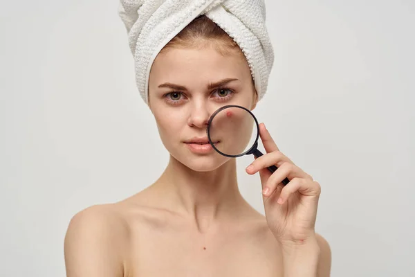 Bonita mujer con una lupa en dermatología mano aislado fondo — Foto de Stock