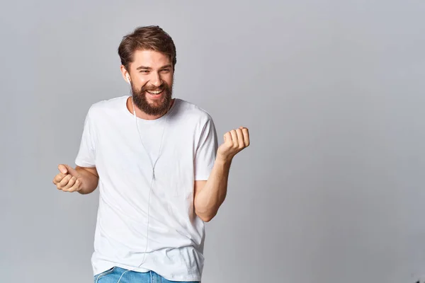 Vrolijke man gebaren met zijn handen in een wit t-shirt casual dragen dans — Stockfoto