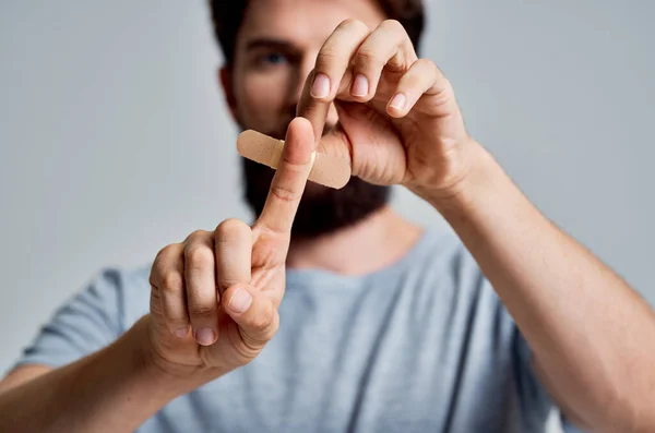 Hombre con parche de dedo lesionado tratamiento de salud —  Fotos de Stock