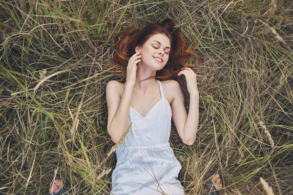 Mulher bonita encontra-se na grama no campo natureza resto — Fotografia de Stock
