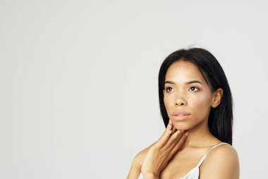 Beyaz tişörtlü güzel Afrikalı Amerikalı kadın. Çekici görünüyor. Kozmetik.