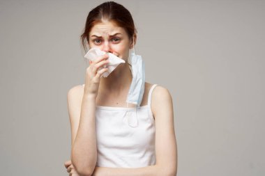 Kırmızı saçlı, beyaz tişörtlü, fularlı bir kadın.