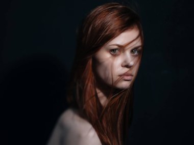 Çıplak omuzlu bir kadın. Kızıl saçlı.