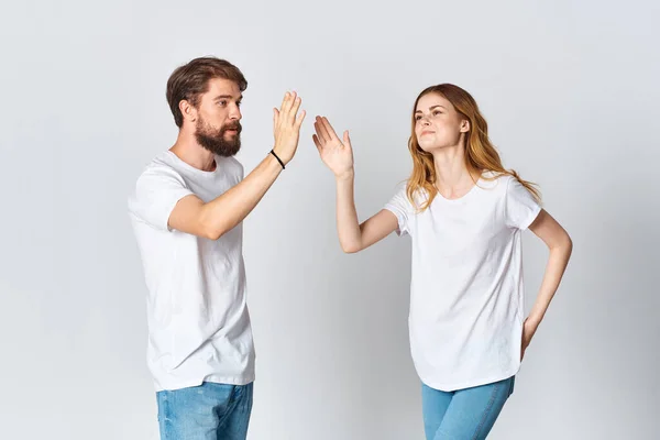 Hombre y mujer en blanco camisetas estudio moda posando divertido fondo de luz — Foto de Stock