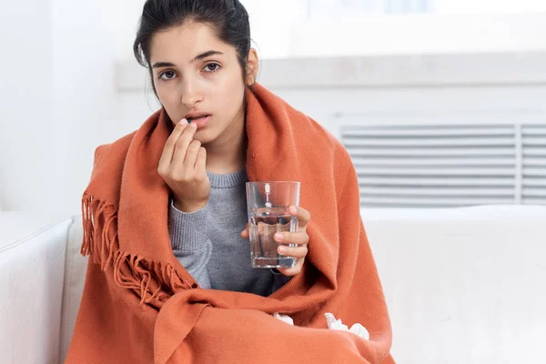Mujer con un resfriado con un vaso de agua beber medicamentos problemas de salud — Foto de Stock