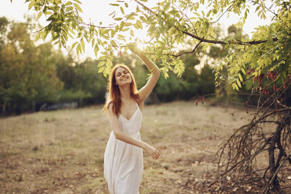Pretty woman in the field nature trees green leaves. High quality photo