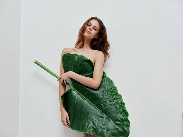 Kvinna med grön palm löv glamour naken kropp ljus bakgrund — Stockfoto