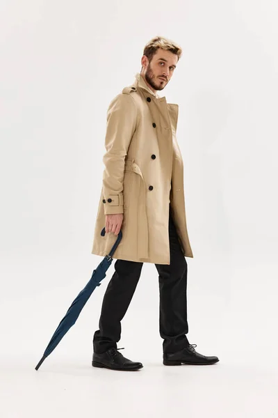 Mężczyzna z parasolem beżowy płaszcz nowoczesny styl — Zdjęcie stockowe