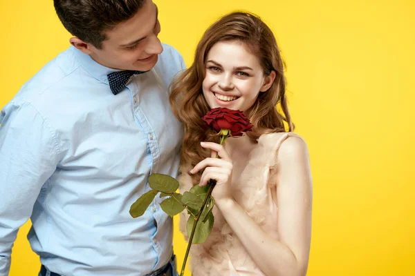 Férfi és nő virág romantika kapcsolat sárga háttér — Stock Fotó