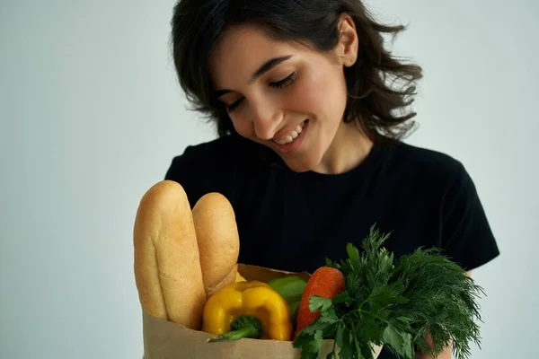 Mujer alegre en una camiseta negra bolsa de alimentos verduras comida saludable de cerca —  Fotos de Stock