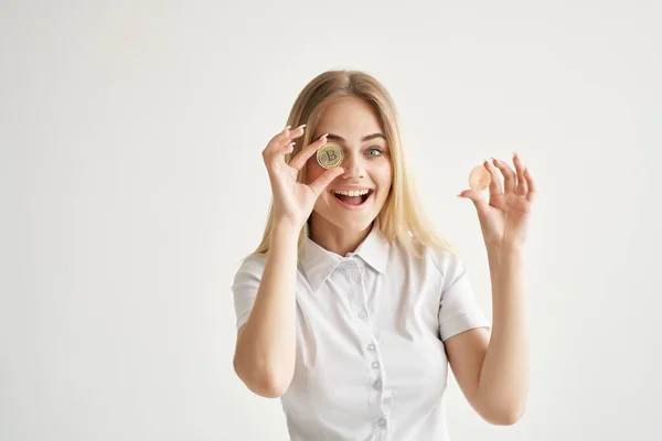 Vrolijke vrouw met gouden munten cryptogeld Bitcoin lichte achtergrond — Stockfoto