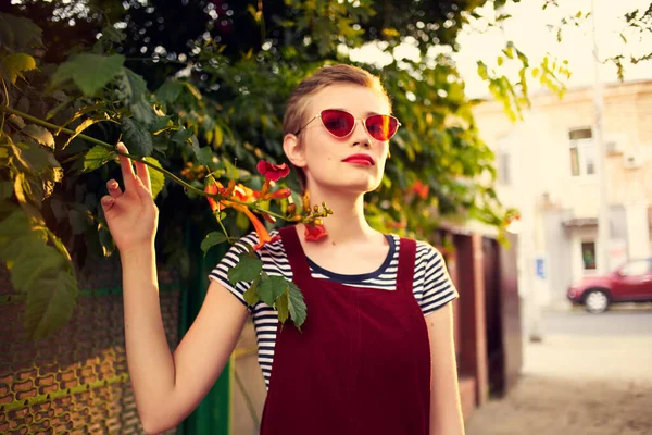 Vacker kvinna bär solglasögon utomhus mode poserar blommor — Stockfoto