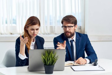 Meslektaşlarım dizüstü bilgisayar uzmanlarının önünde masa başında oturuyorlar.