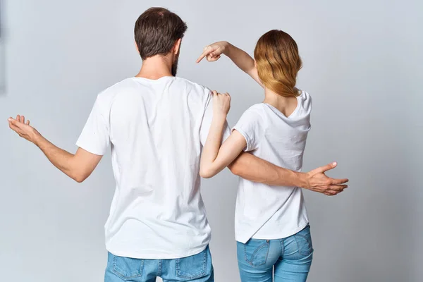 Чоловік і жінка, обіймаючись у білих футболках, маскують задній перегляд — стокове фото