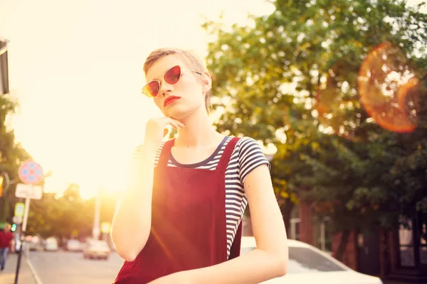 Fröhliche Frau mit Sonnenbrille, die draußen in der Stadt spaziert — Stockfoto