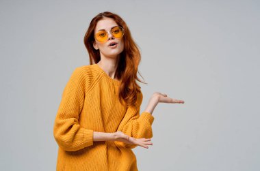 Sarı gözlüklü güzel bir kadın eğlenceli bir yaşam tarzı ışıklandırması yapıyor.