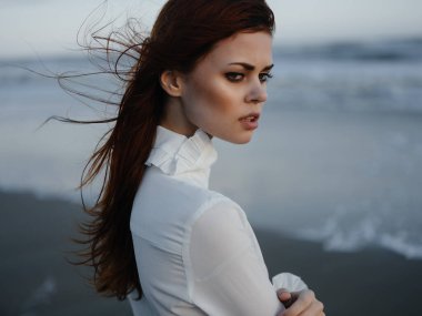 Beyaz elbiseli güzel bir kadın. Sahilde lüks içinde yürüyor.