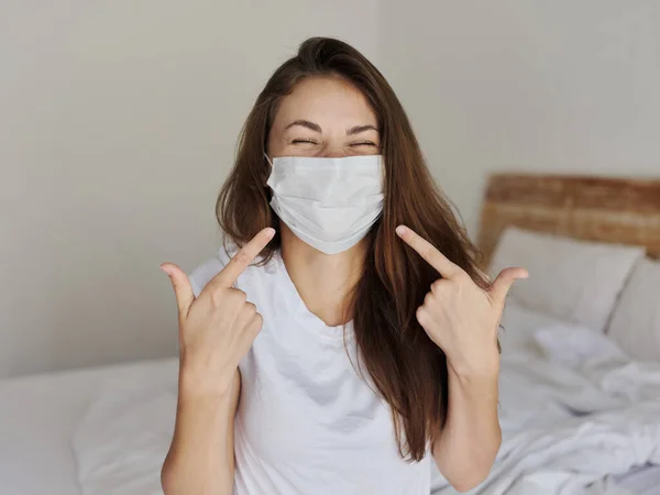 Fröhliche Frau zeigt eine medizinische Maske auf ihrem Gesicht — Stockfoto