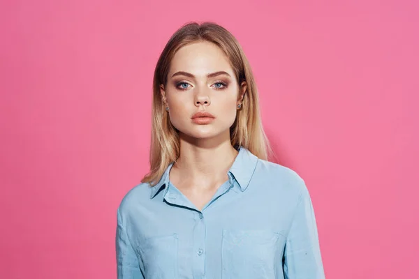 可愛いですブロンドで青いシャツ化粧品ピンクの背景 — ストック写真