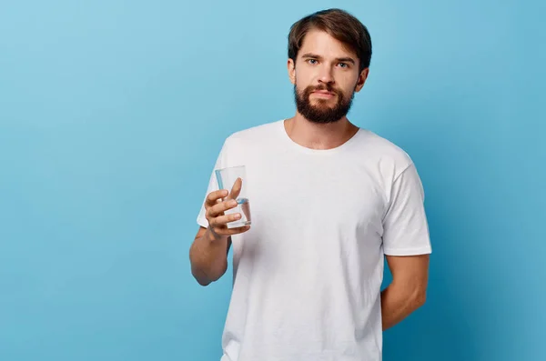 Homem em branco t-shirt beber água azul fundo — Fotografia de Stock