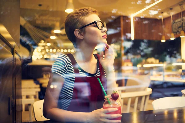 女人坐在咖啡馆里，享受着鸡尾酒般的生活休闲 — 图库照片