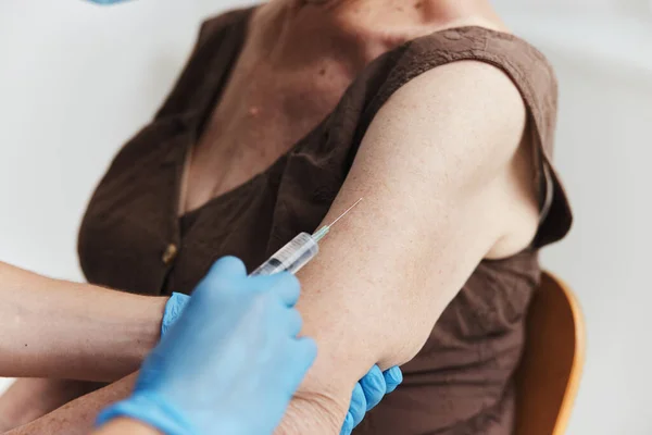 Vacunación de una mujer anciana coronavirus pandémico —  Fotos de Stock